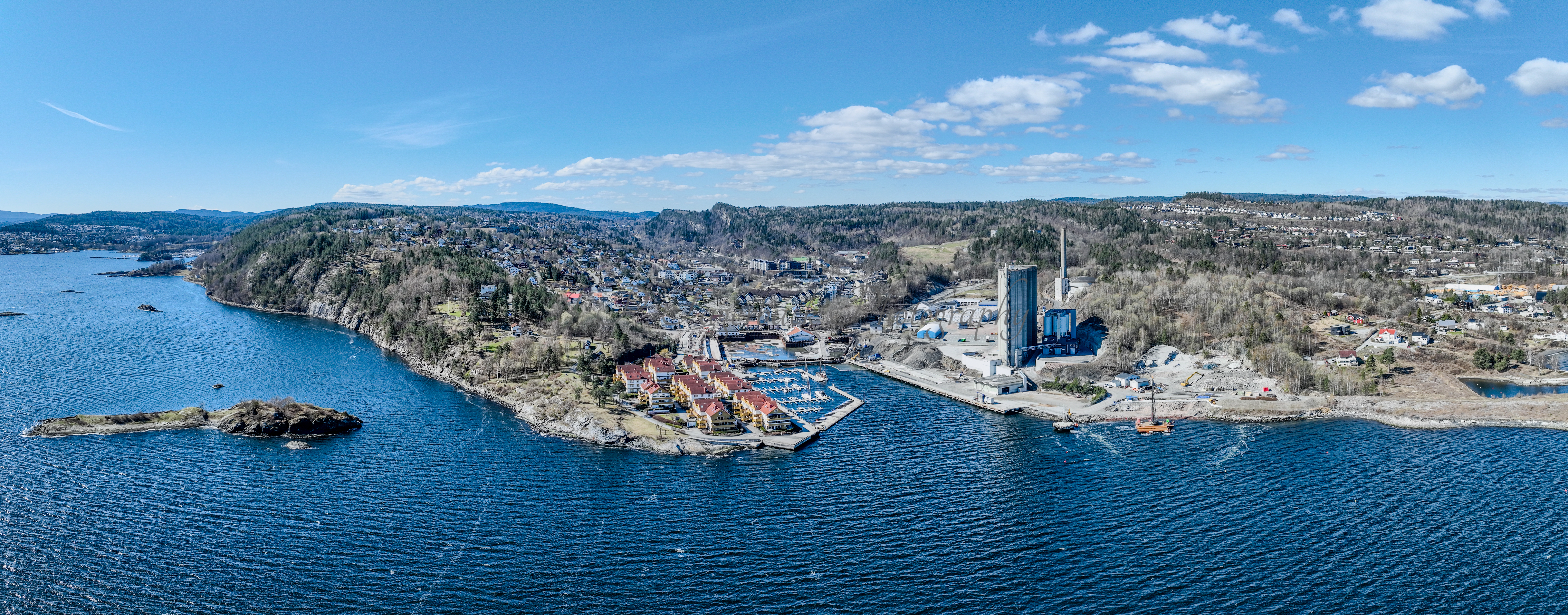 Buildings seen from a body of water with a blue sky