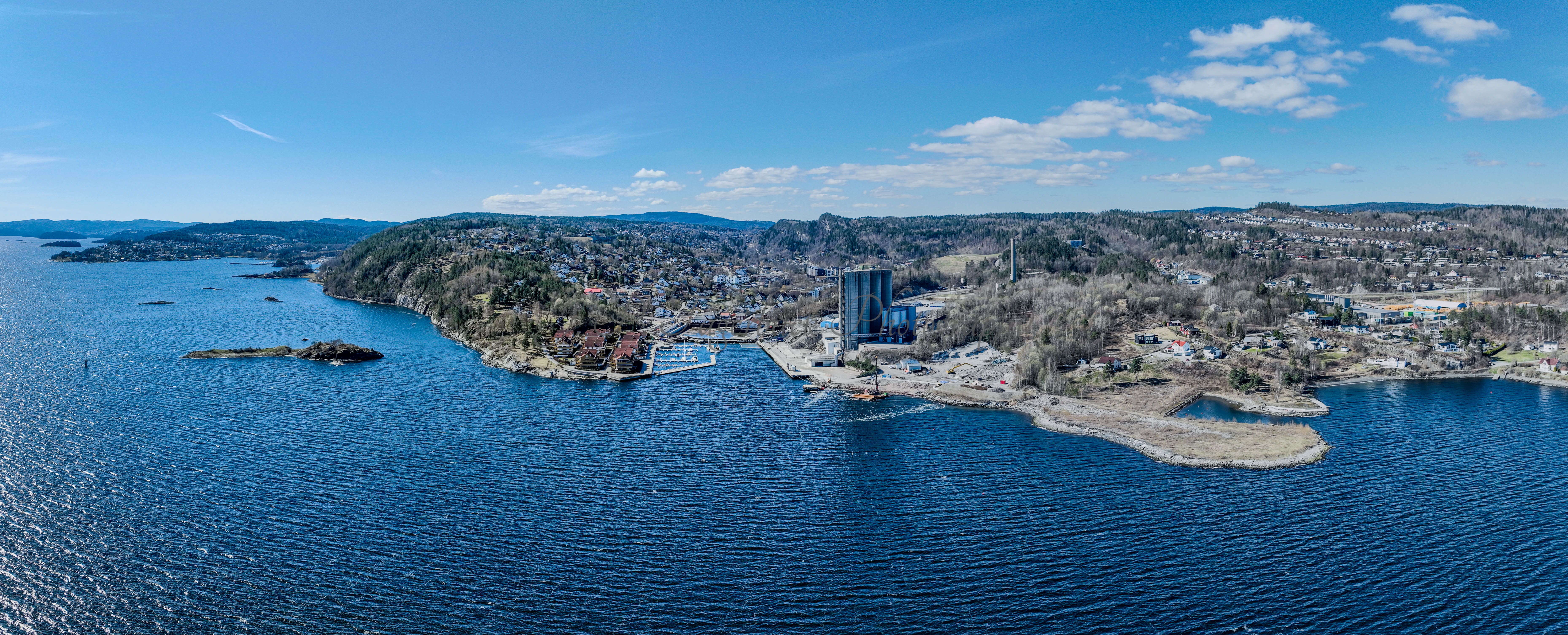 Buildings seen from a body of water with a blue sky