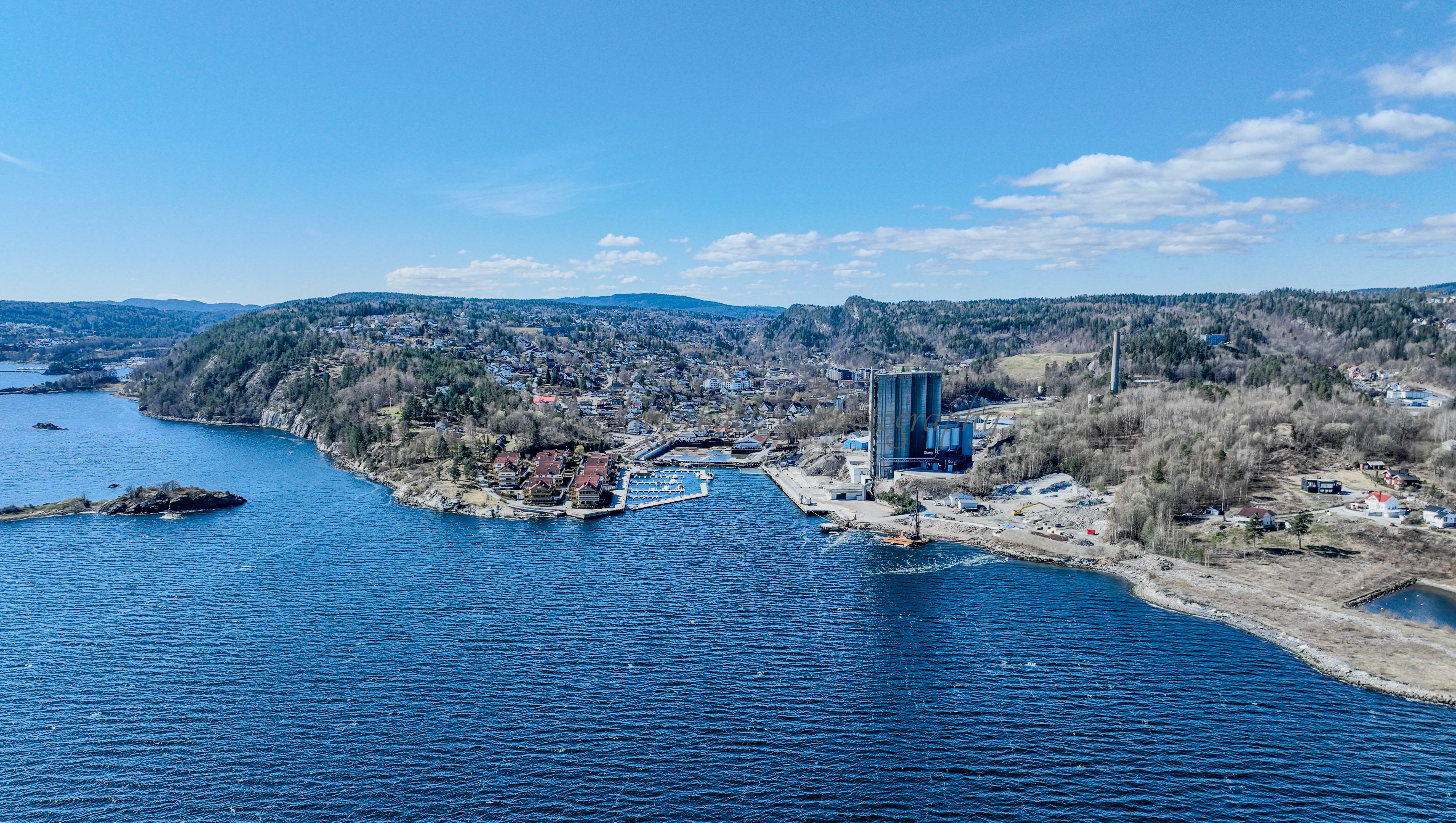 Buildings seen from a body of water with a blue sky