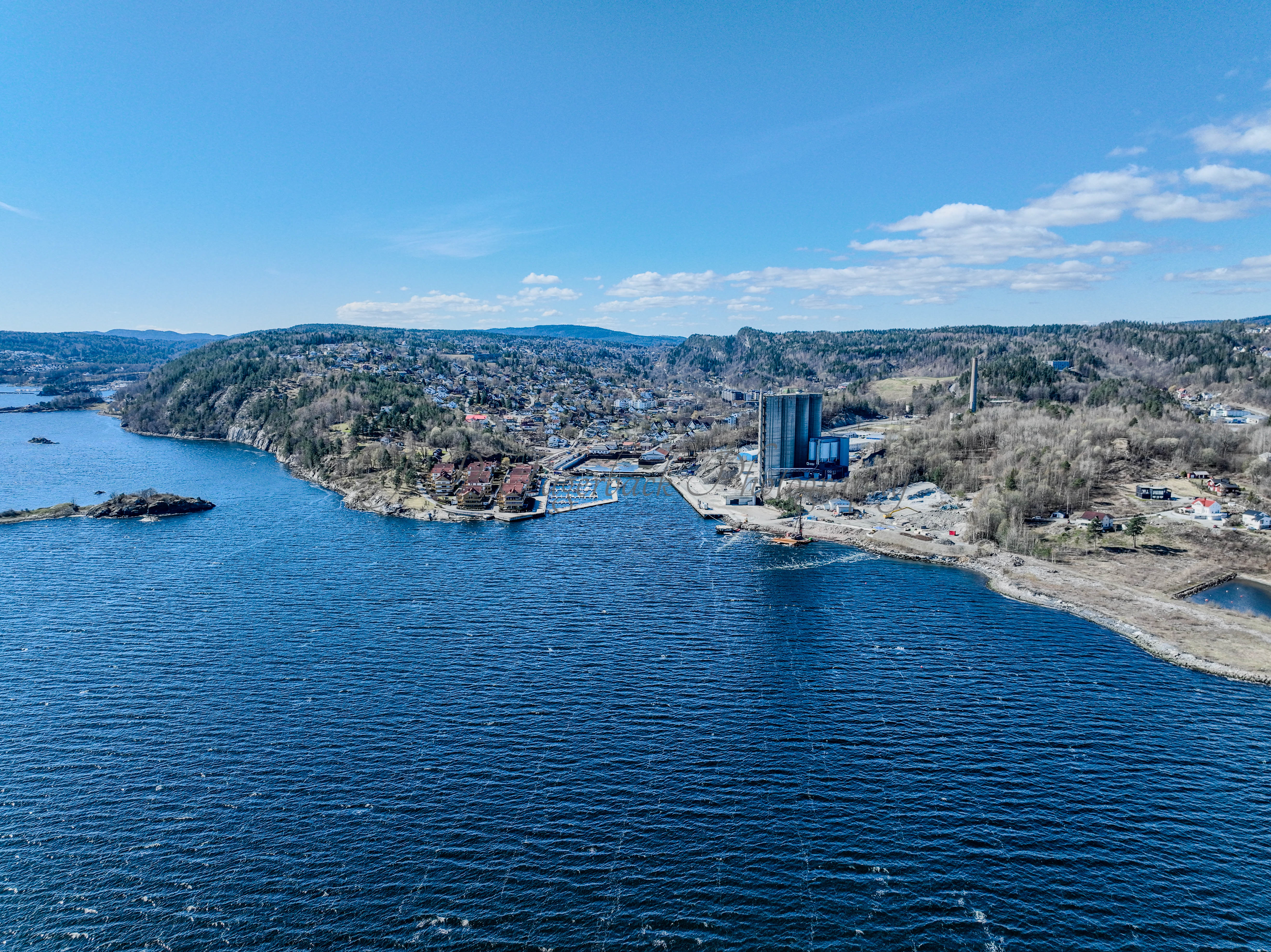 Buildings seen from a body of water with a blue sky