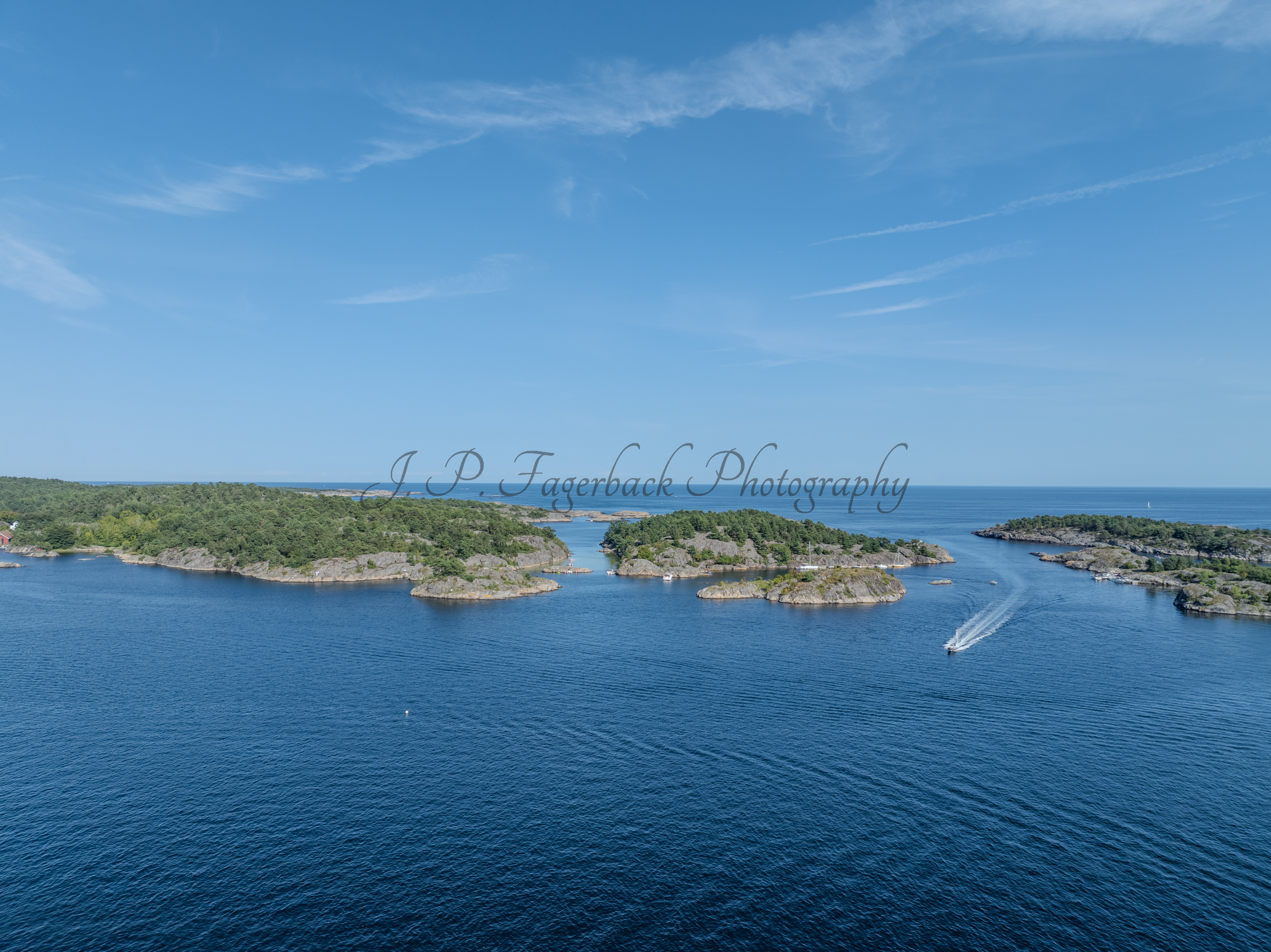 Islands with green vegitaions in sourounded by blue ocean water under a blue sky