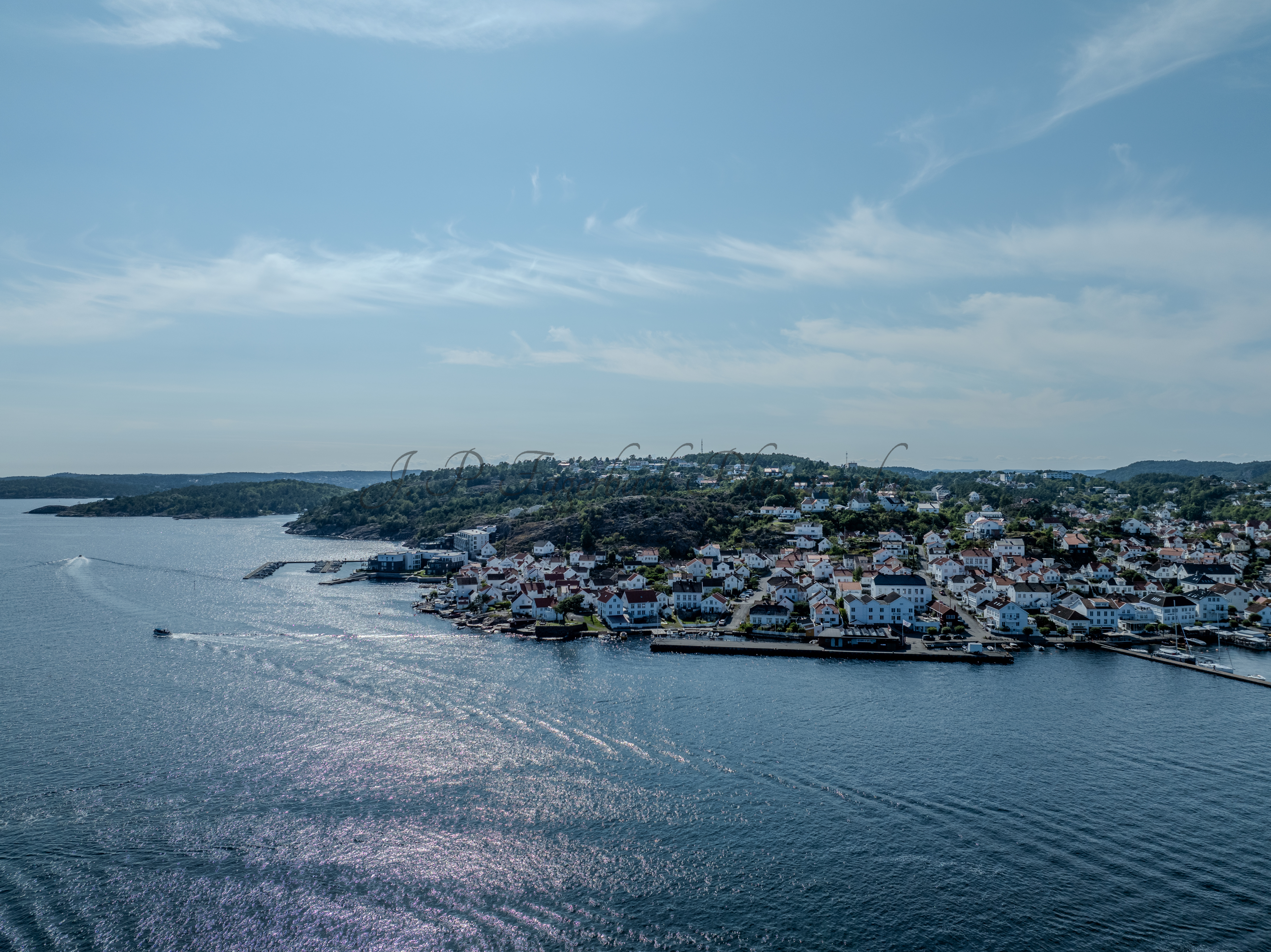 A town with small white houses along a shoreline