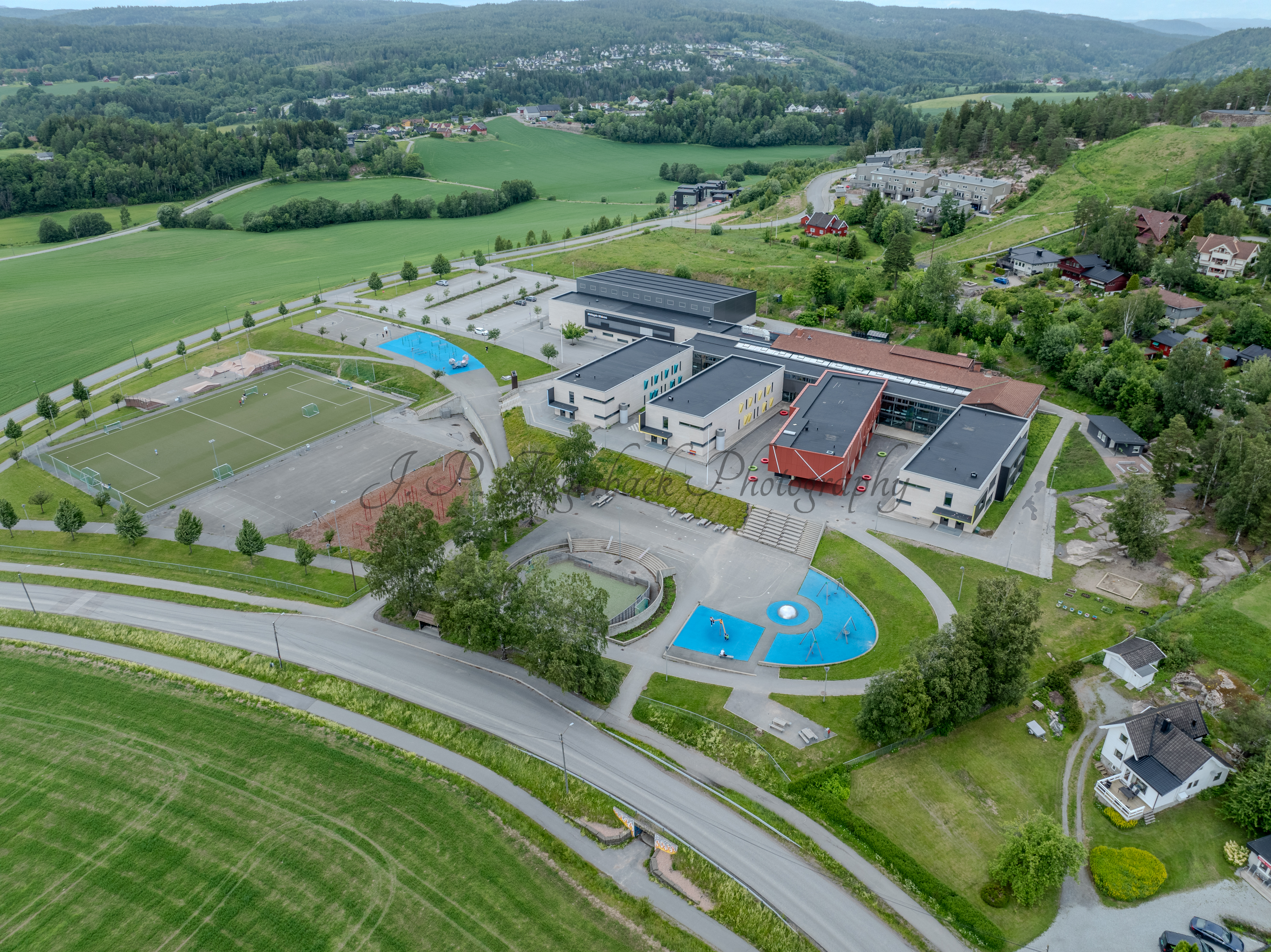 Colorfull school buildings in an are with other houses and green fields