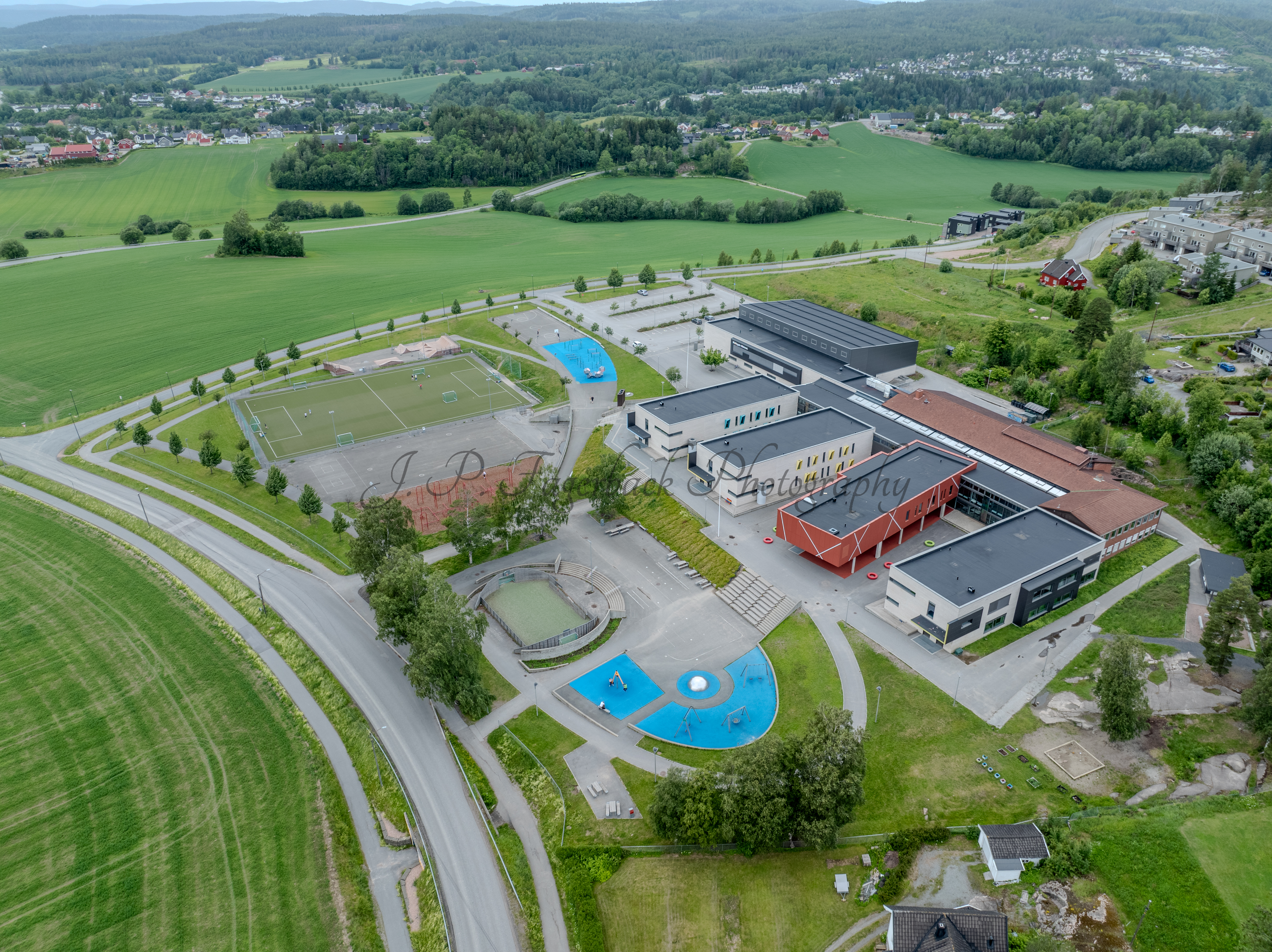Colorfull school buildings in an are with other houses and green fields