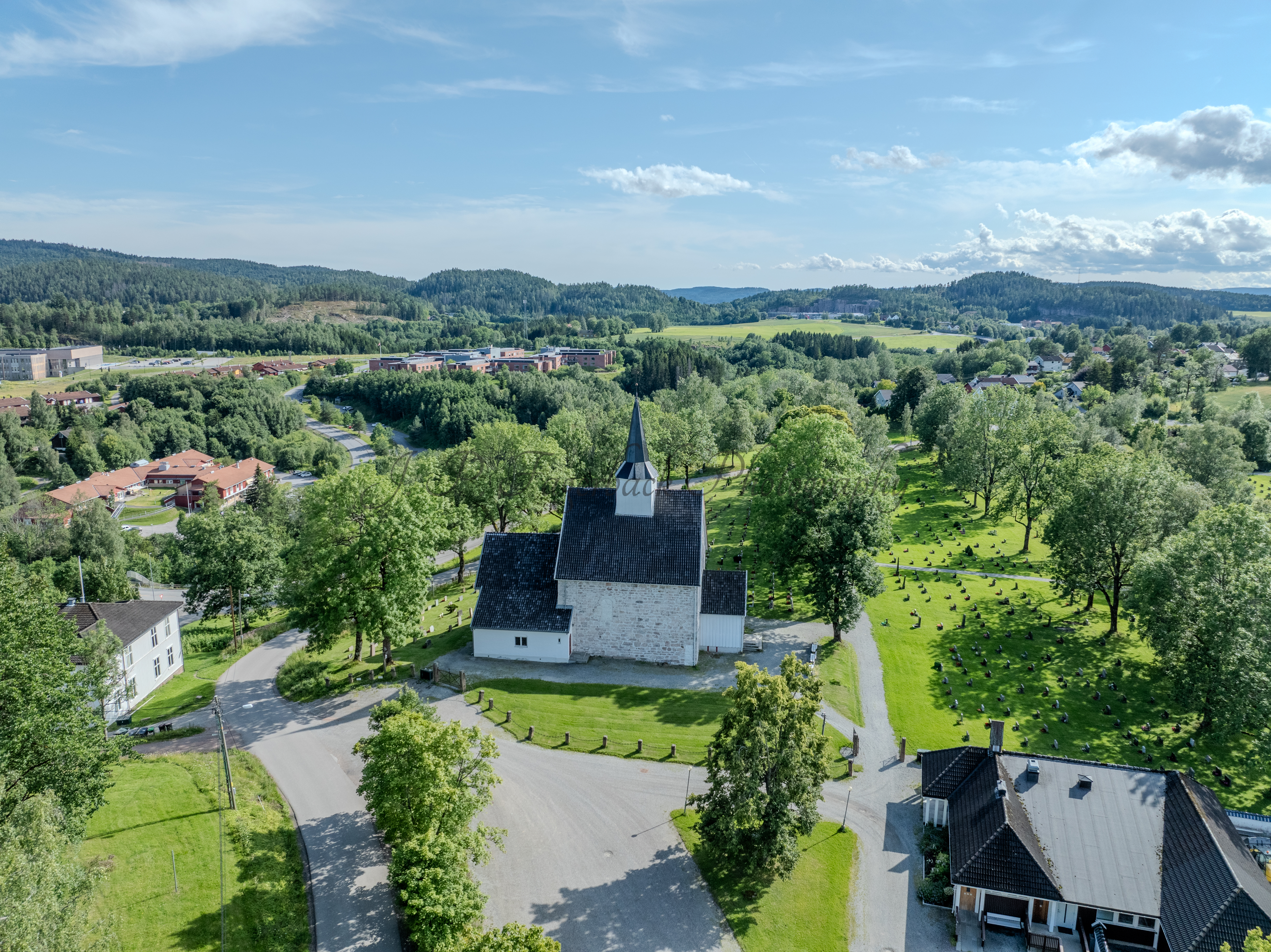 White stone church in a green landscape under a blue sky
