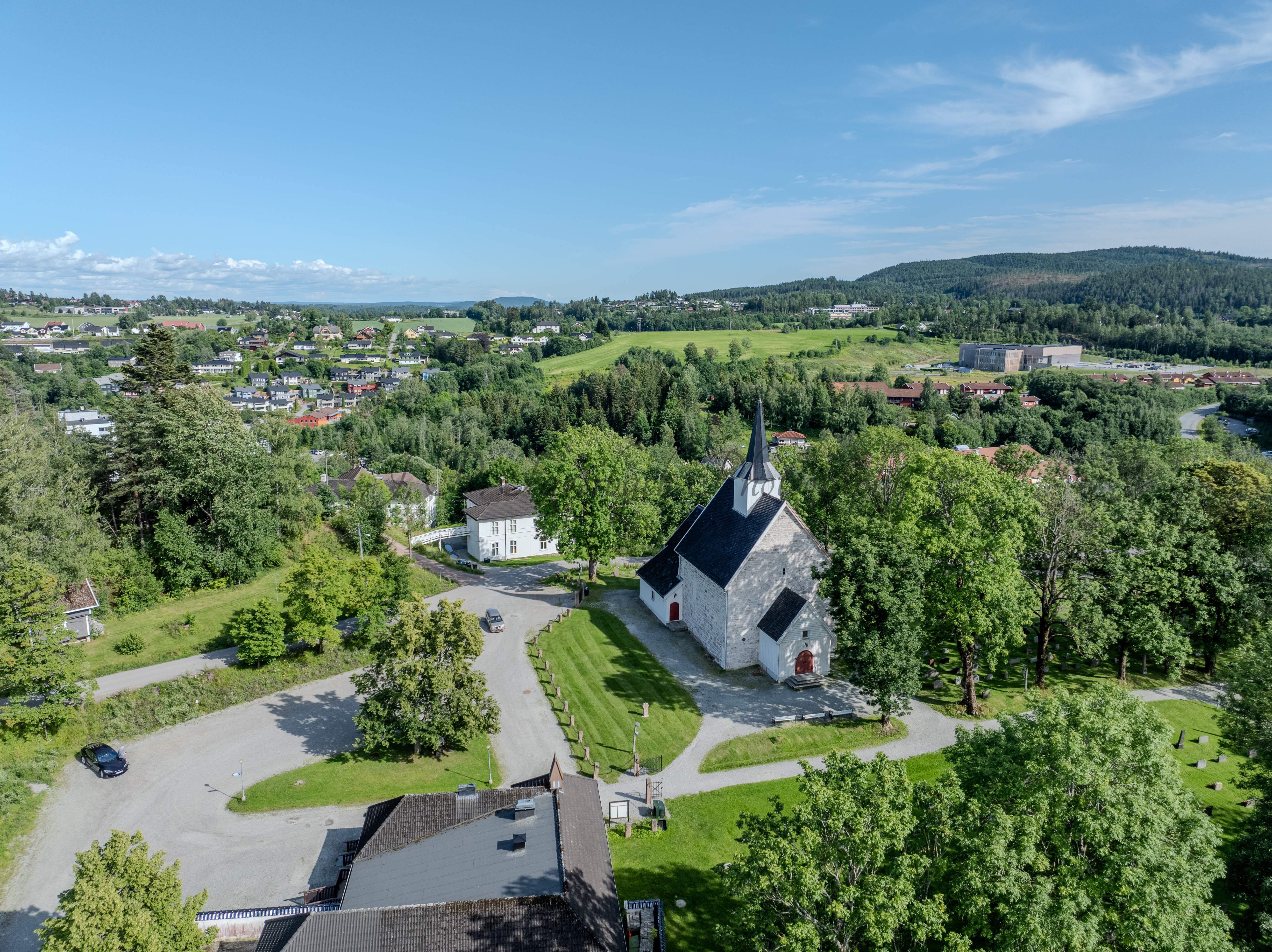 White stone church in a green landscape under a blue sky