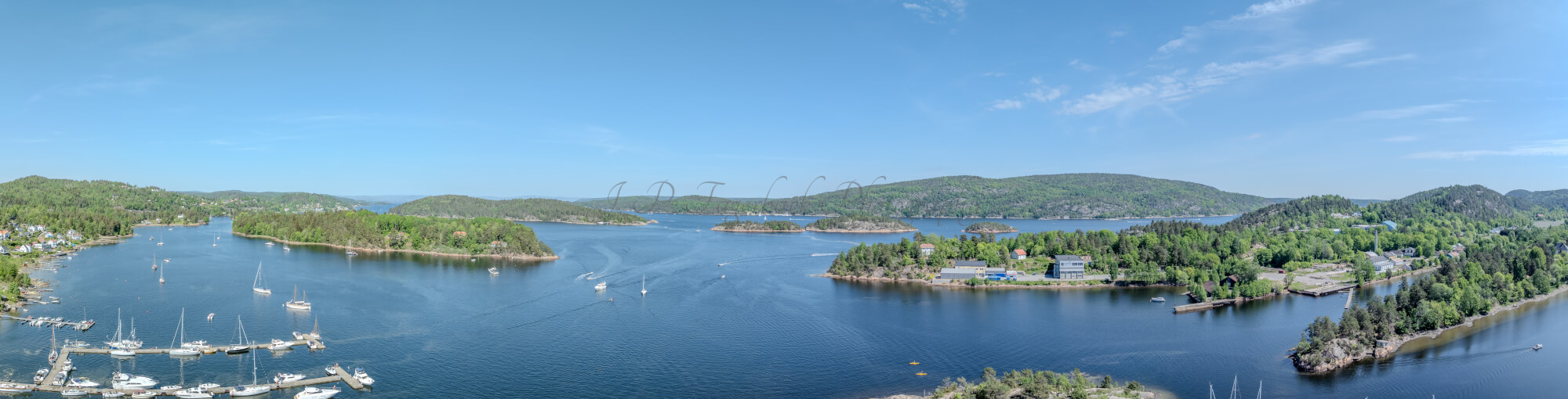 Buildings seen from a body of water with a blue sky