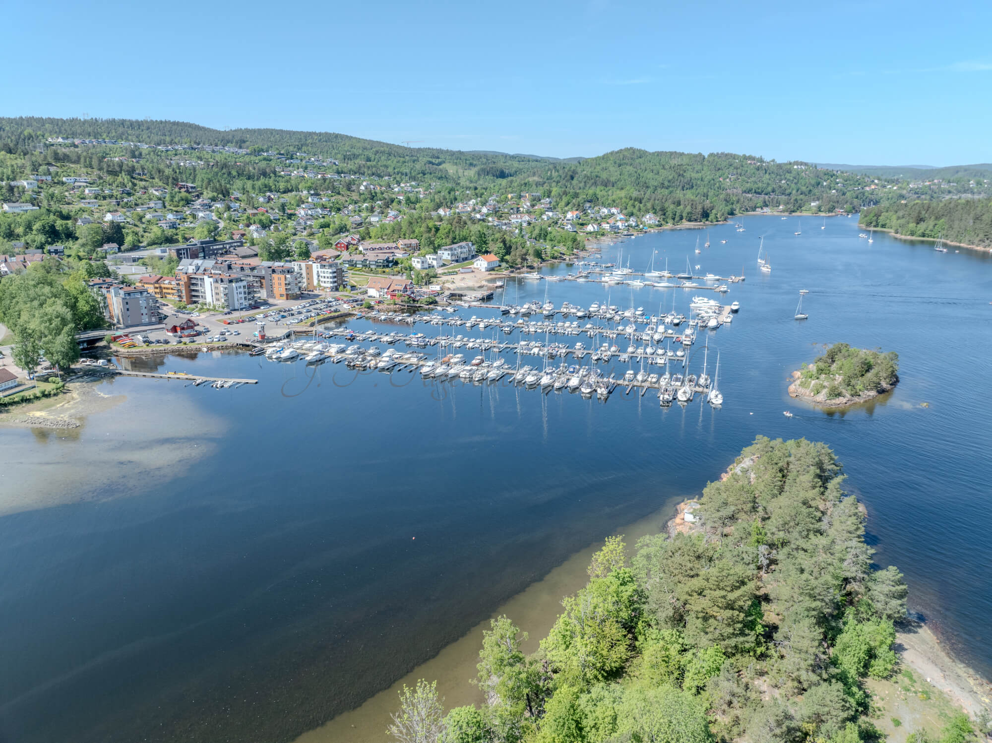 Buildings seen from a body of water with a blue sky
