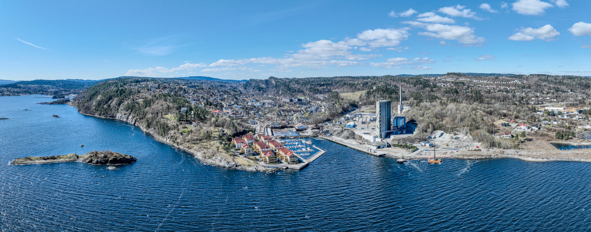 Buildings seen from a body of water with a blue sky