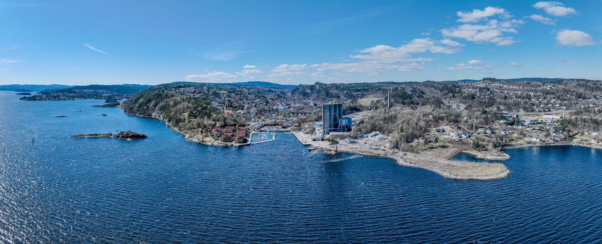 Buildings seen from a body of water with a blue sky