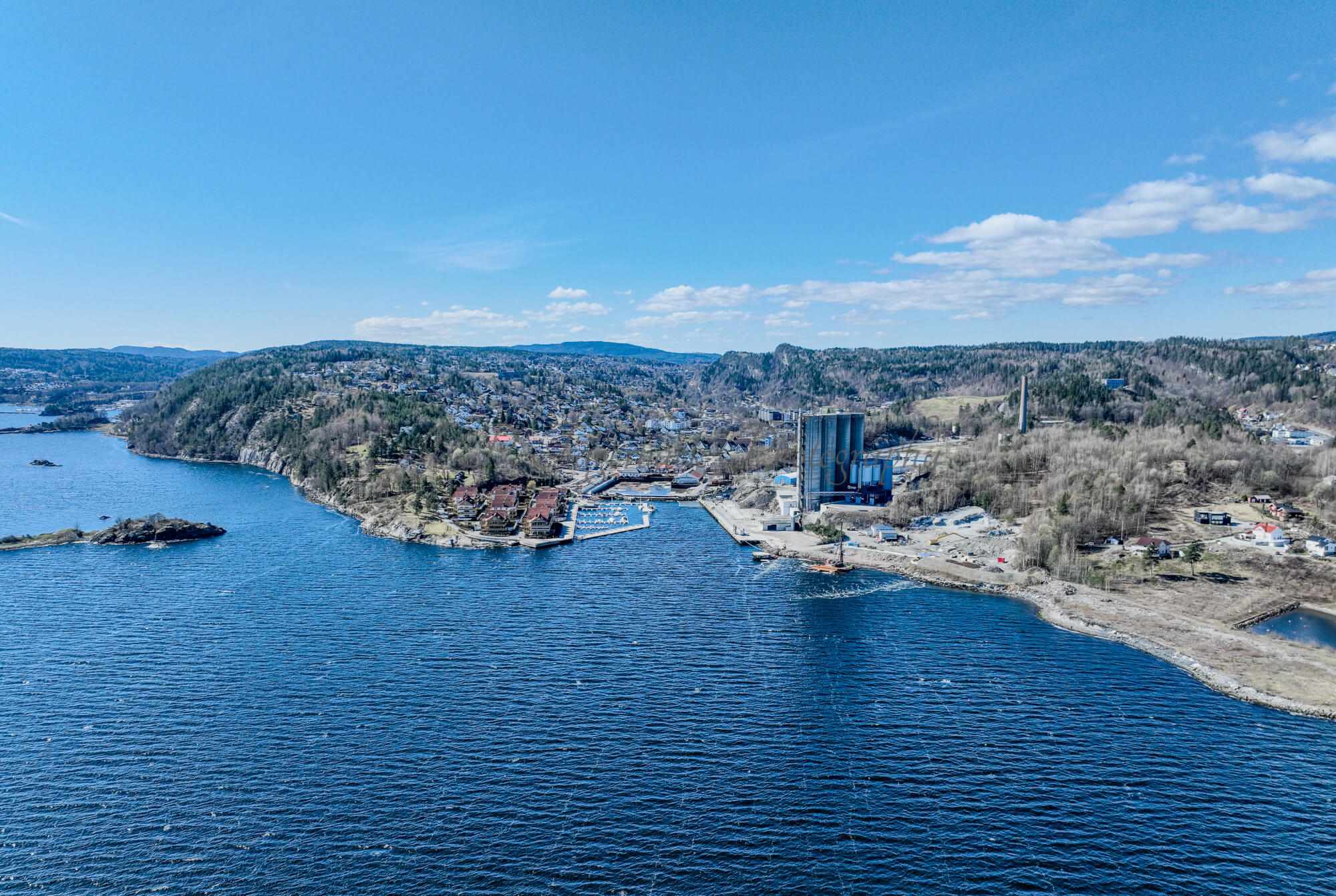 Buildings seen from a body of water with a blue sky