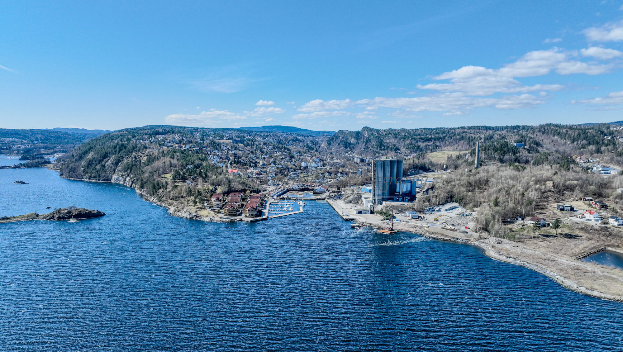 Buildings seen from a body of water with a blue sky
