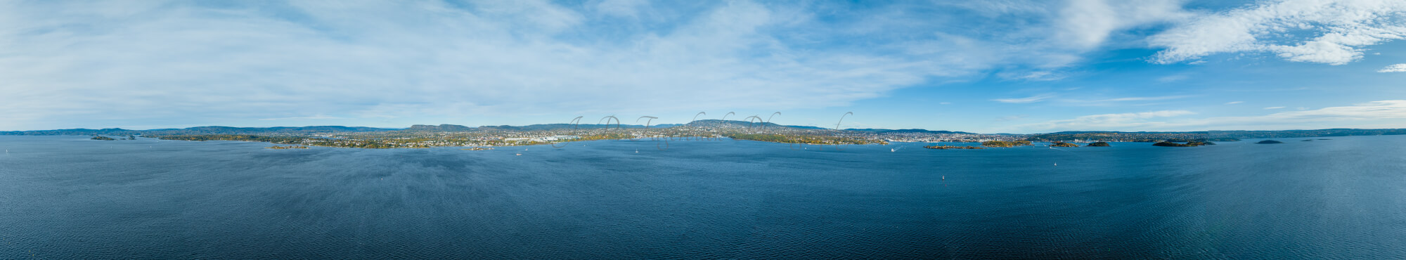 Large body of water with a coast line in the  background under a blue sky