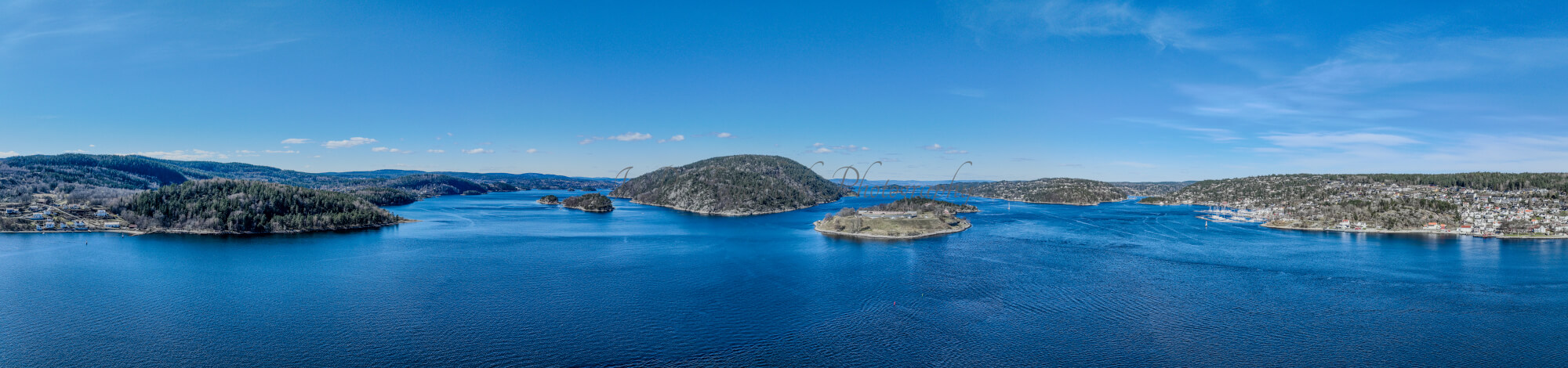 Two islands in a body of water where the right one has a fort on it