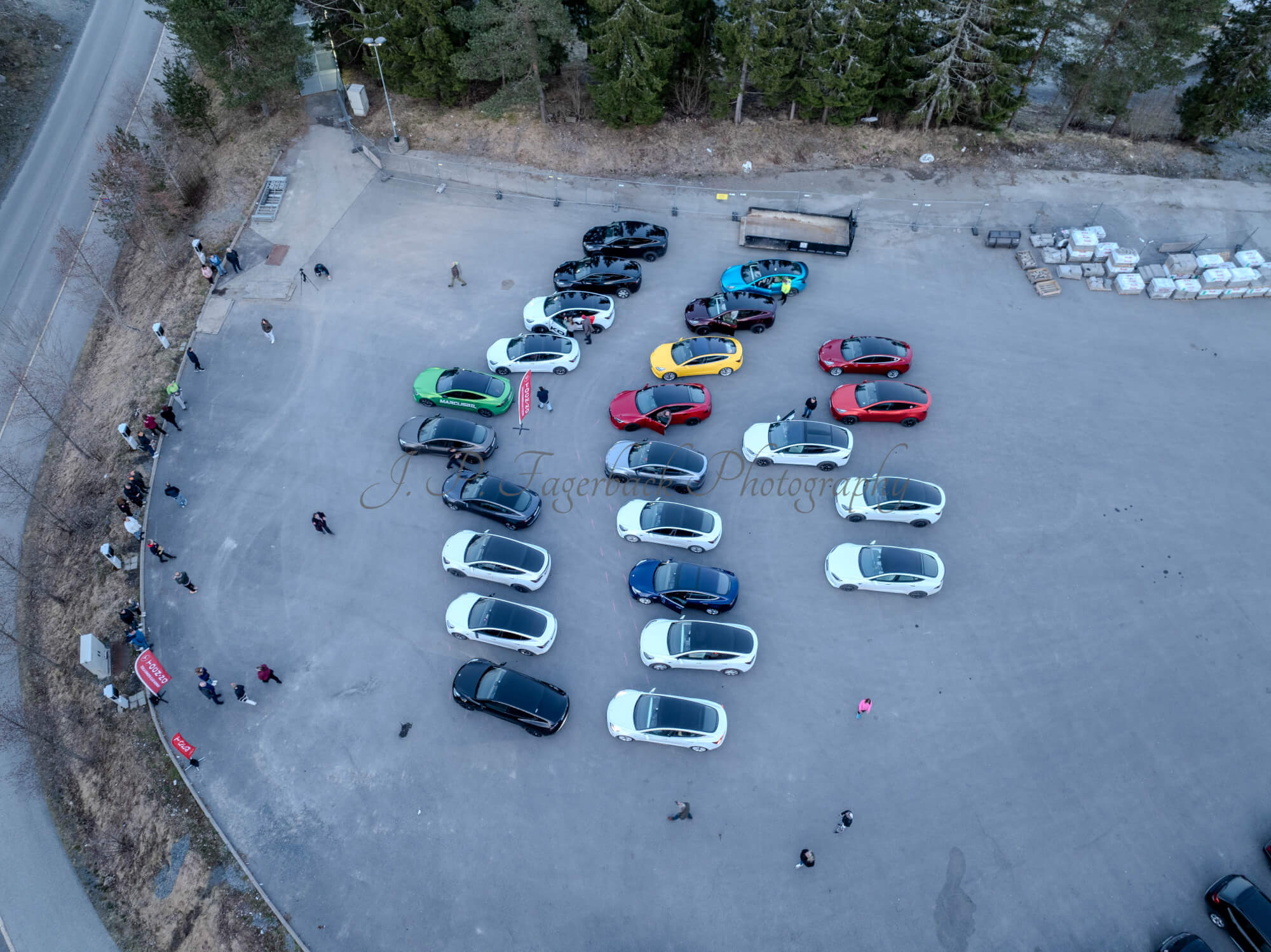 Cars on a parking lot from upon high with a ski jump in the background