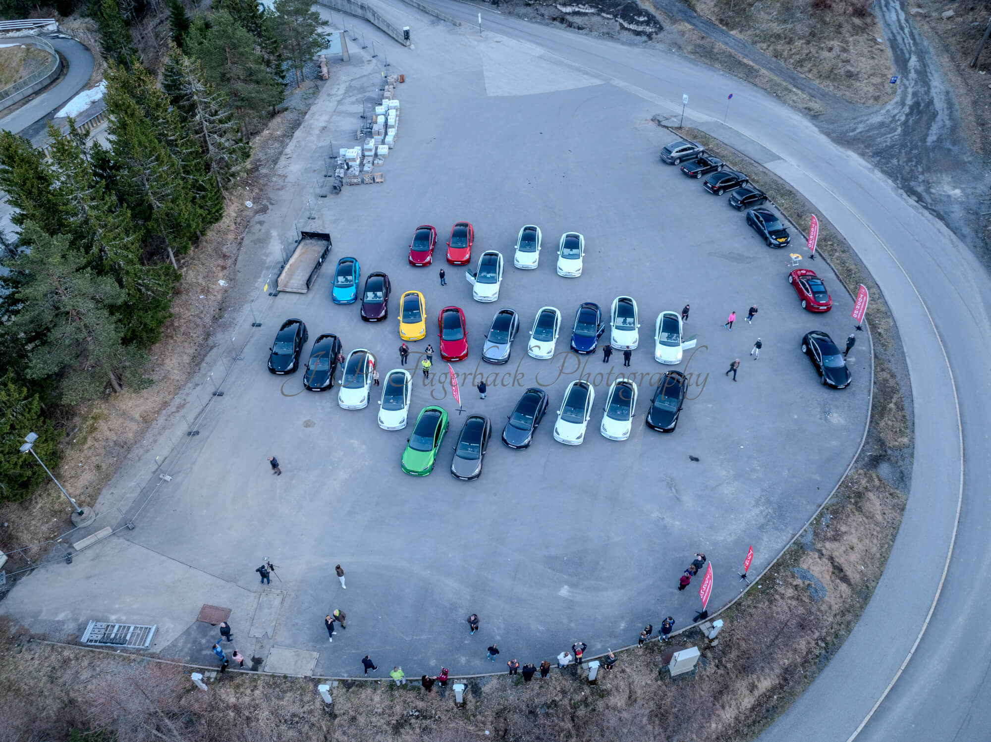 Cars on a parking lot from upon high with a ski jump in the background