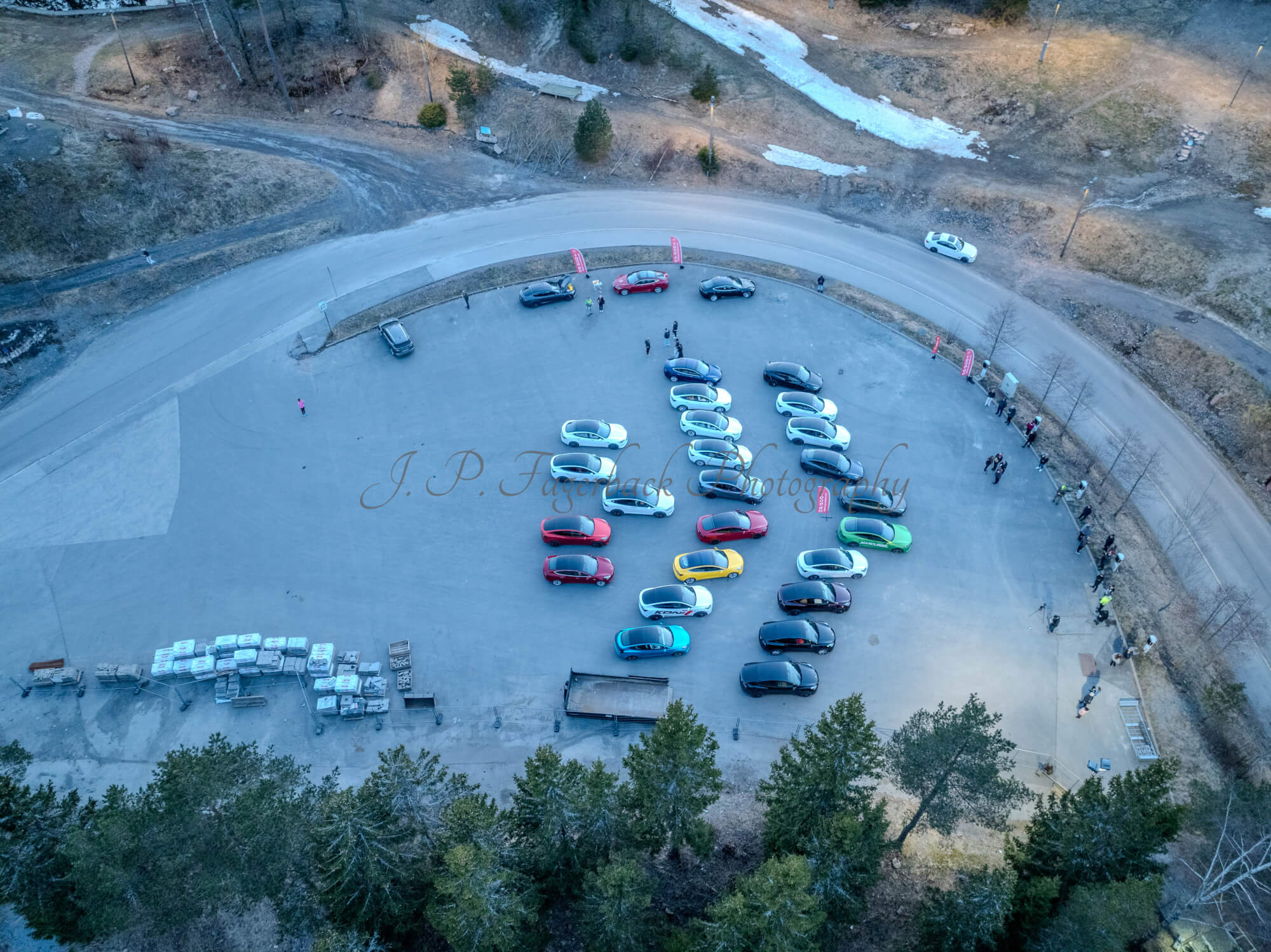 Cars on a parking lot from upon high with a ski jump in the background