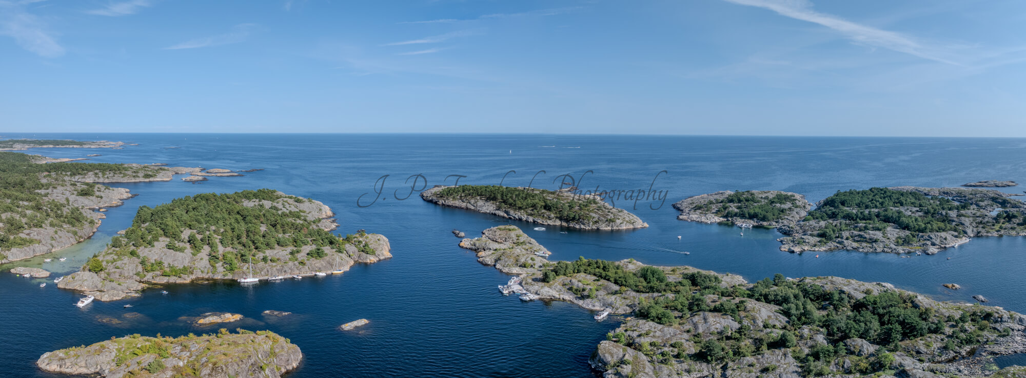 Islands with green vegitaions in sourounded by blue ocean water under a blue sky