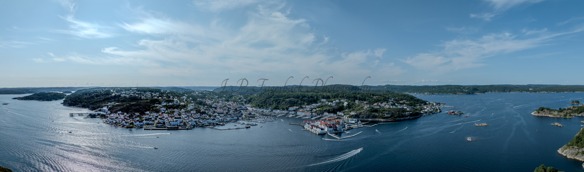 A panorama view of a town with small white houses along a shoreline