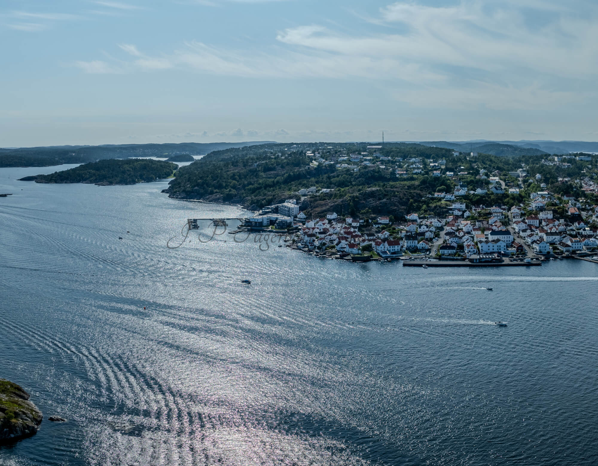 A panorama view of a town with small white houses along a shoreline