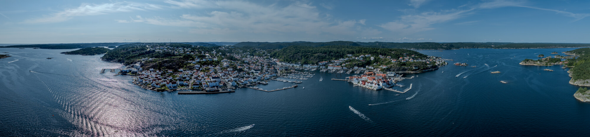 A panorama view of a town with small white houses along a shoreline