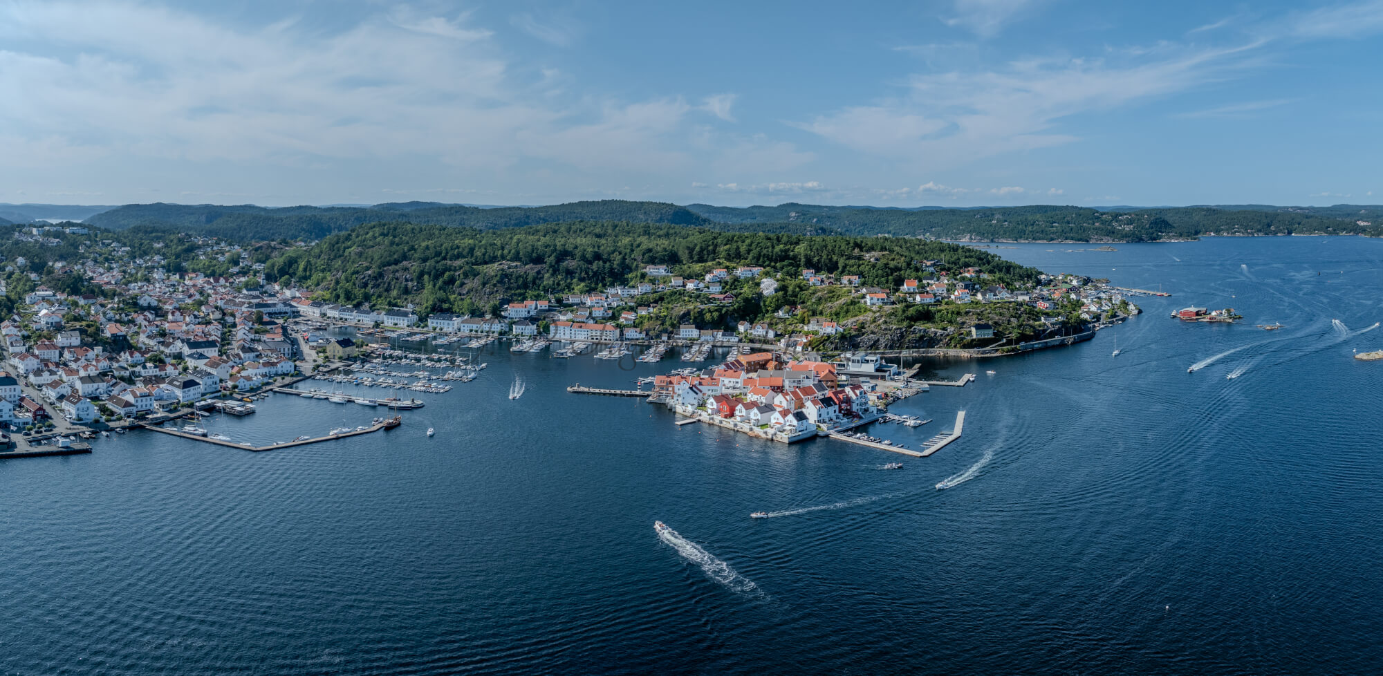 A panorama view of a town with small white houses along a shoreline