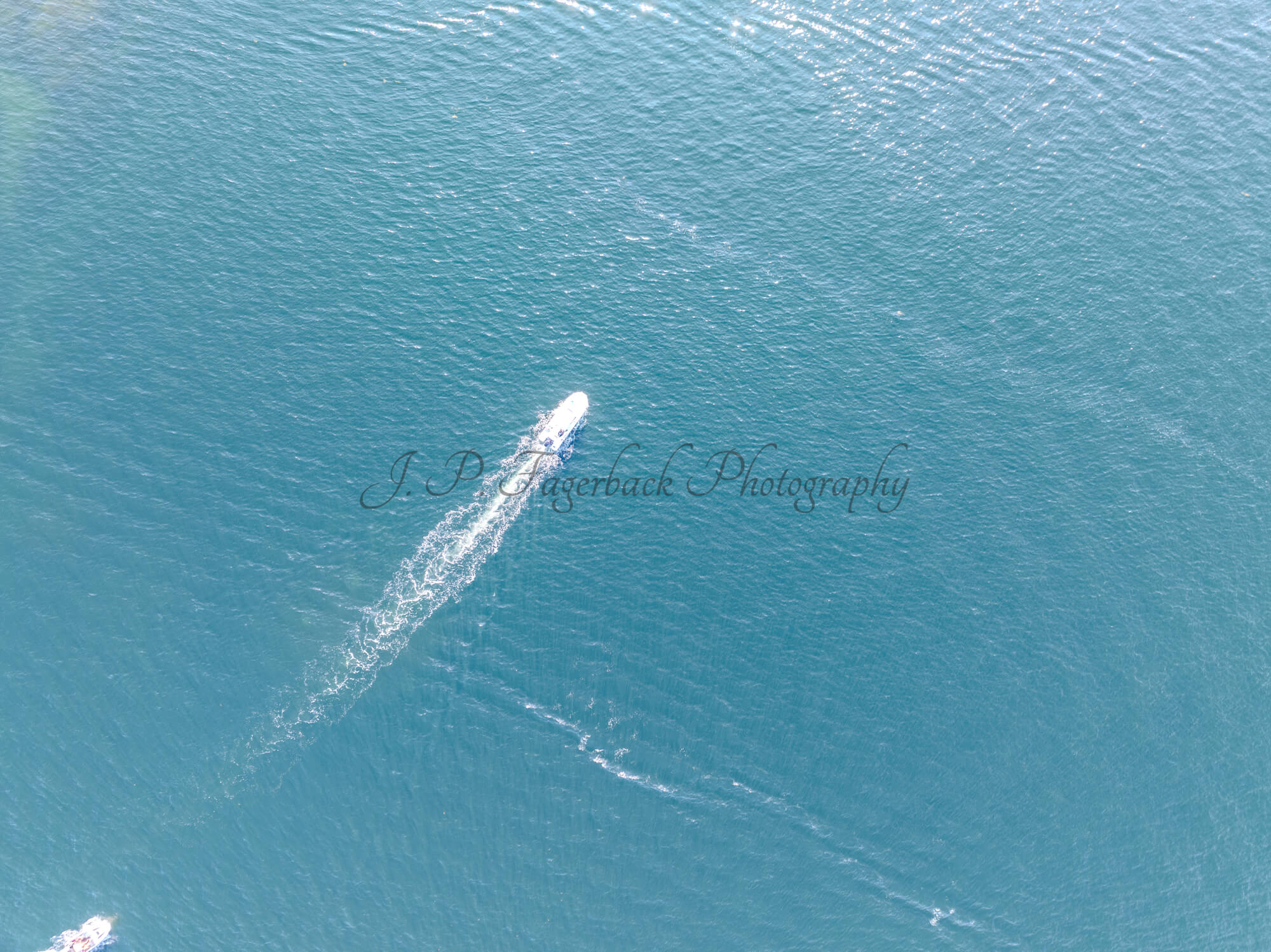 Boats in a blue sea making wakes