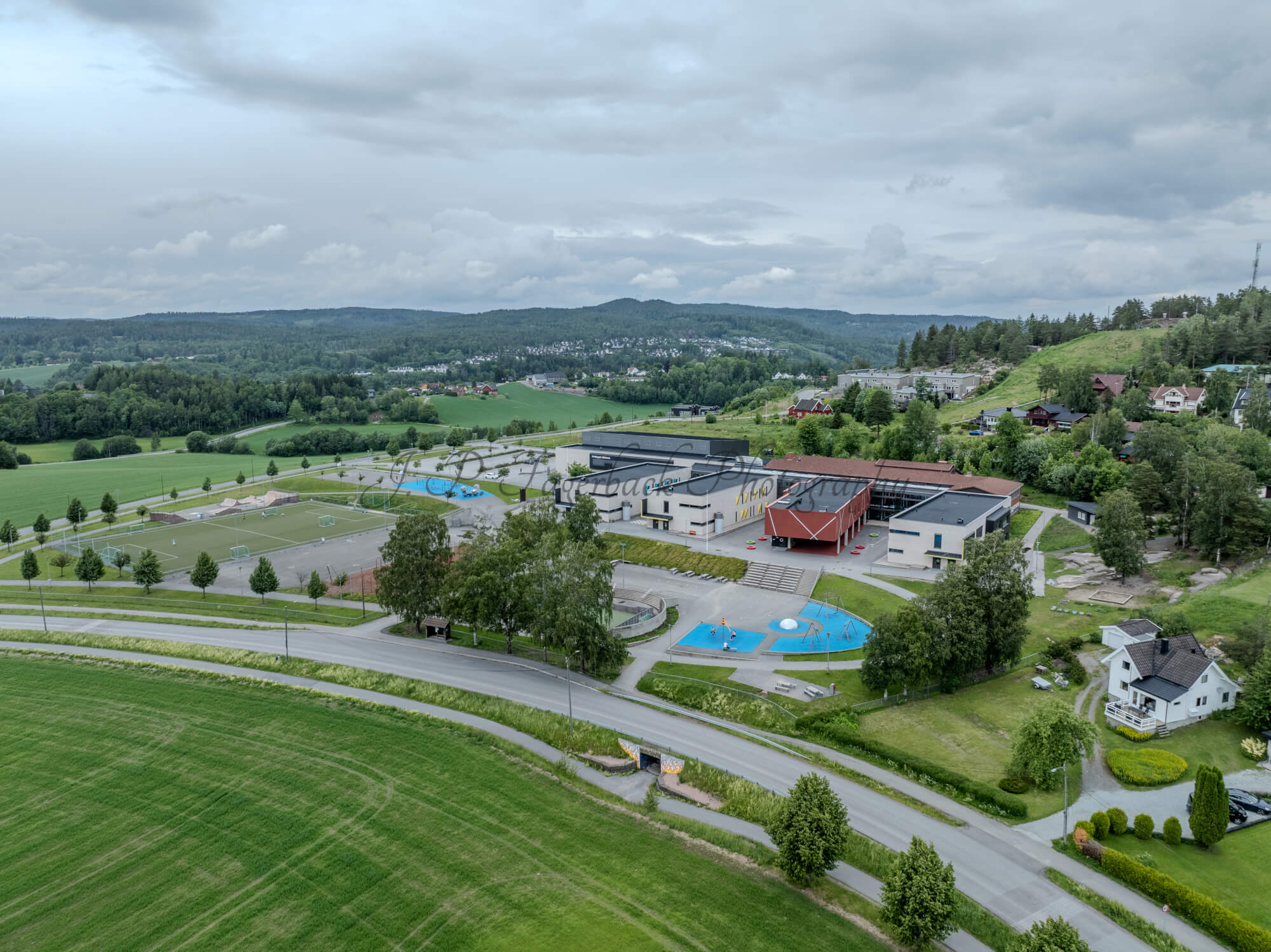 Colorfull school buildings in an are with other houses and green fields