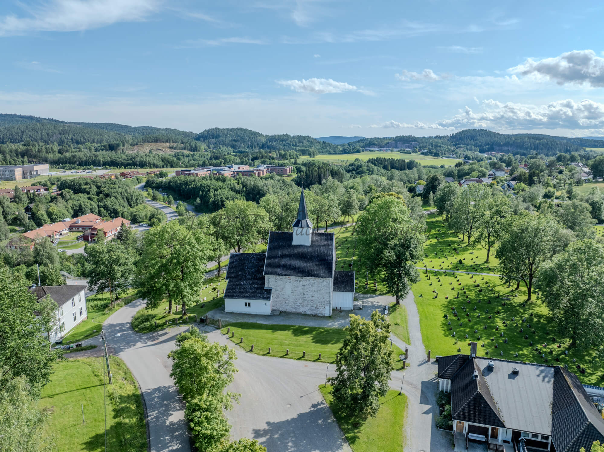 White stone church in a green landscape under a blue sky