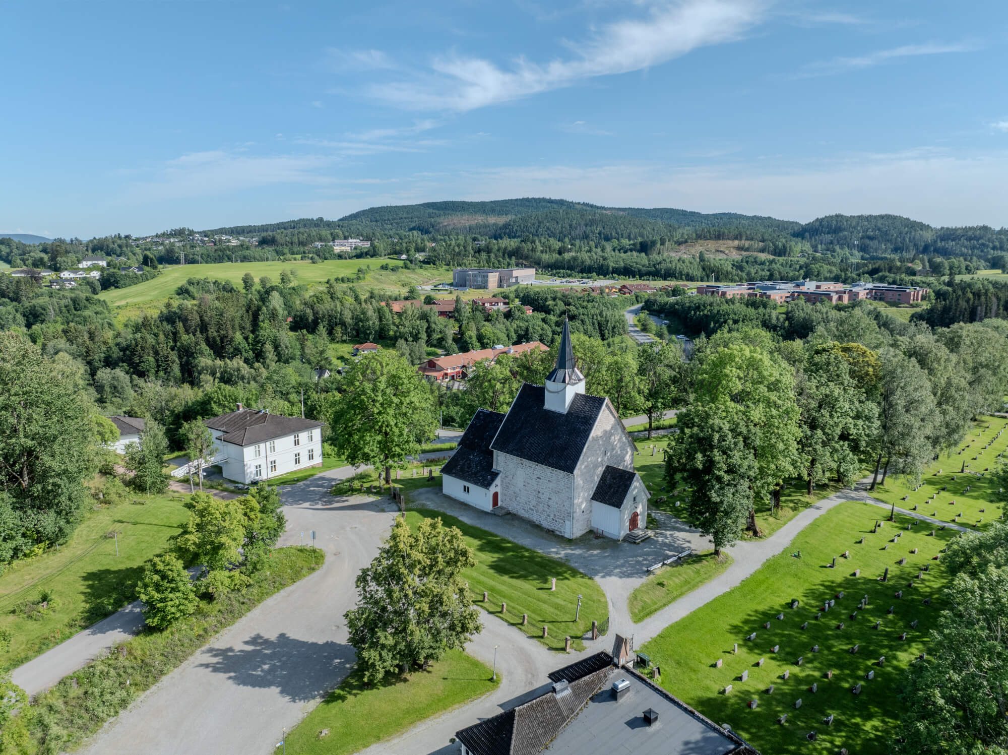 White stone church in a green landscape under a blue sky
