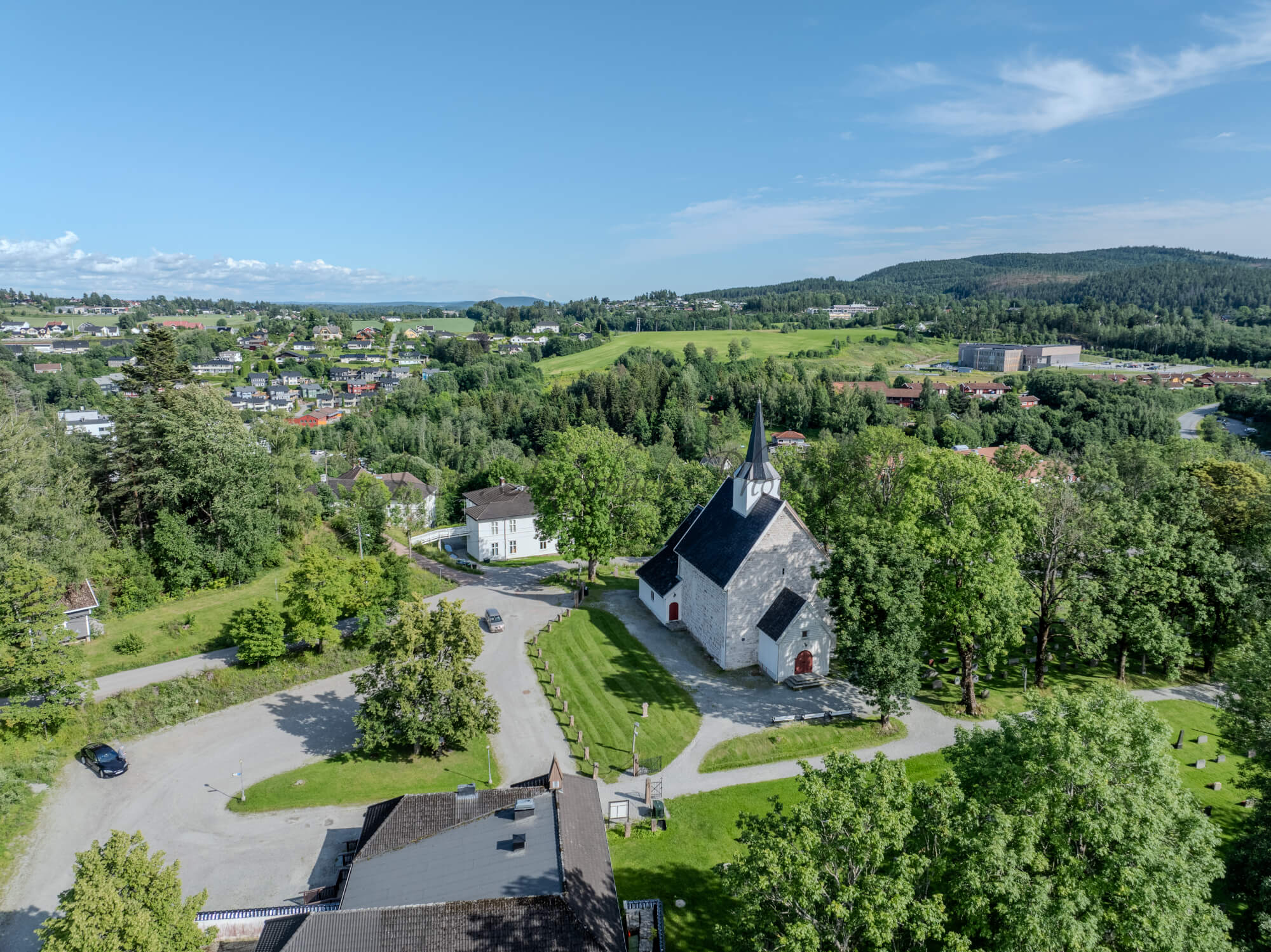 White stone church in a green landscape under a blue sky
