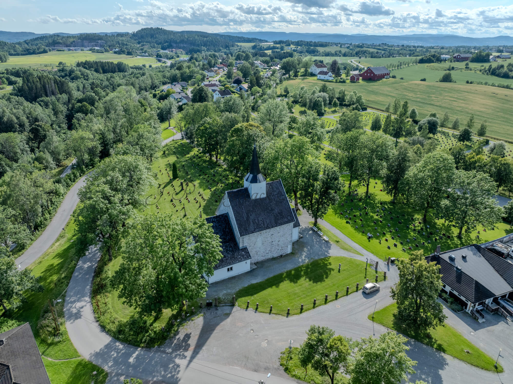 White stone church in a green landscape under a blue sky