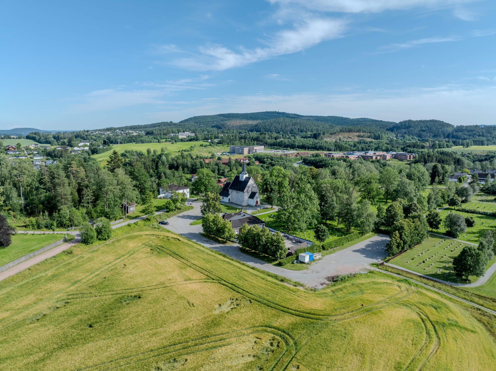 White stone church in a green landscape under a blue sky