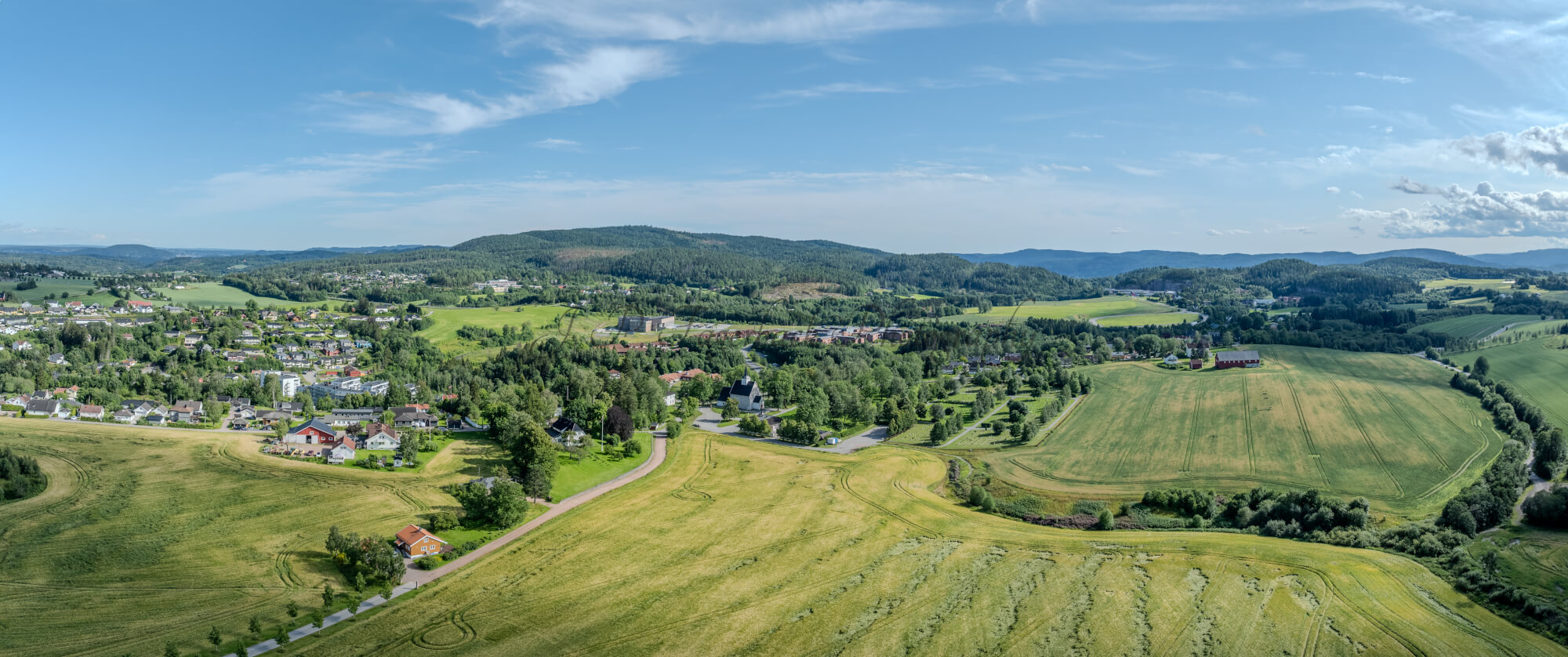 White stone church in background of a green landscape under a blue sky