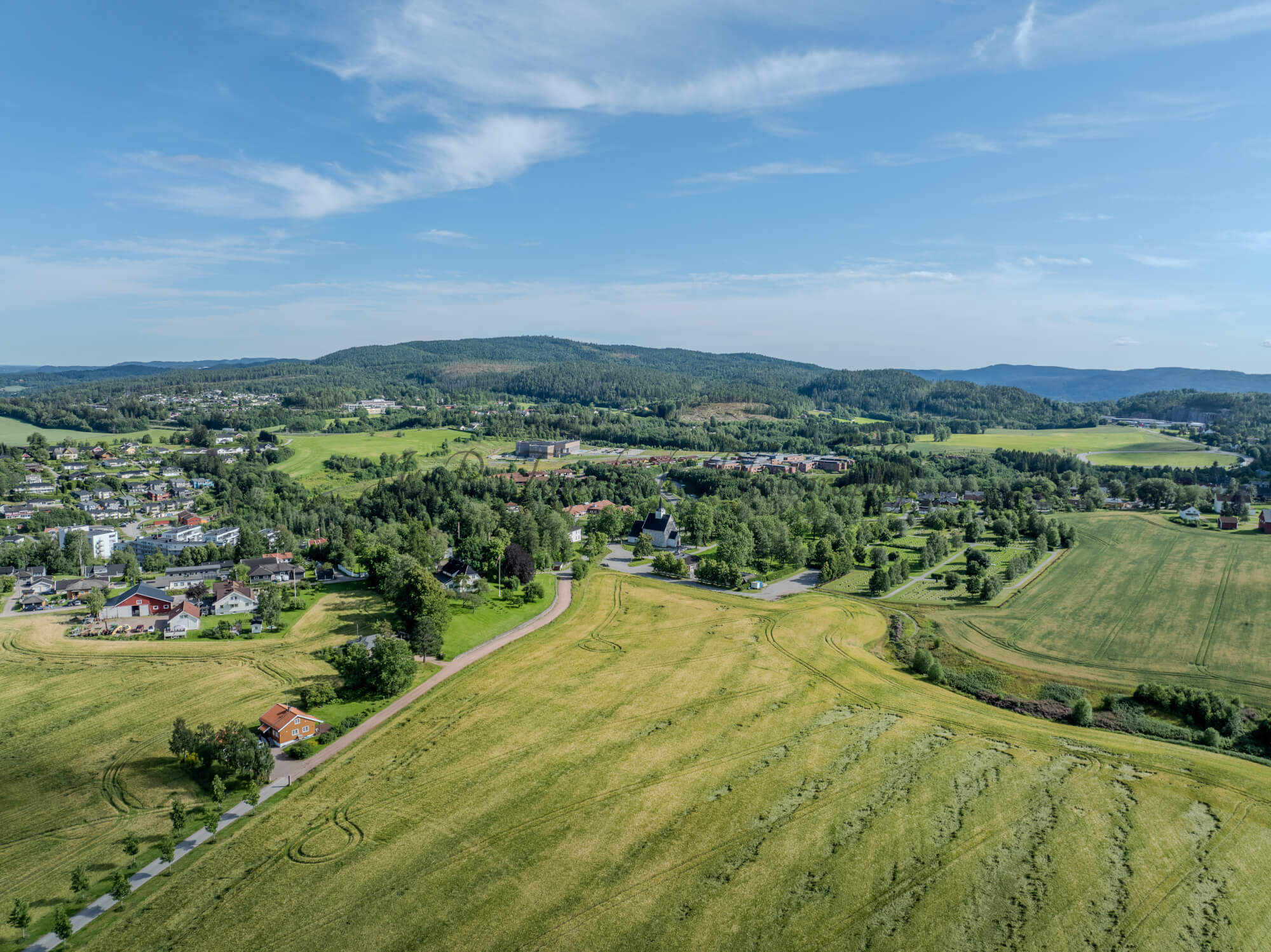 White stone church in background of a green landscape under a blue sky