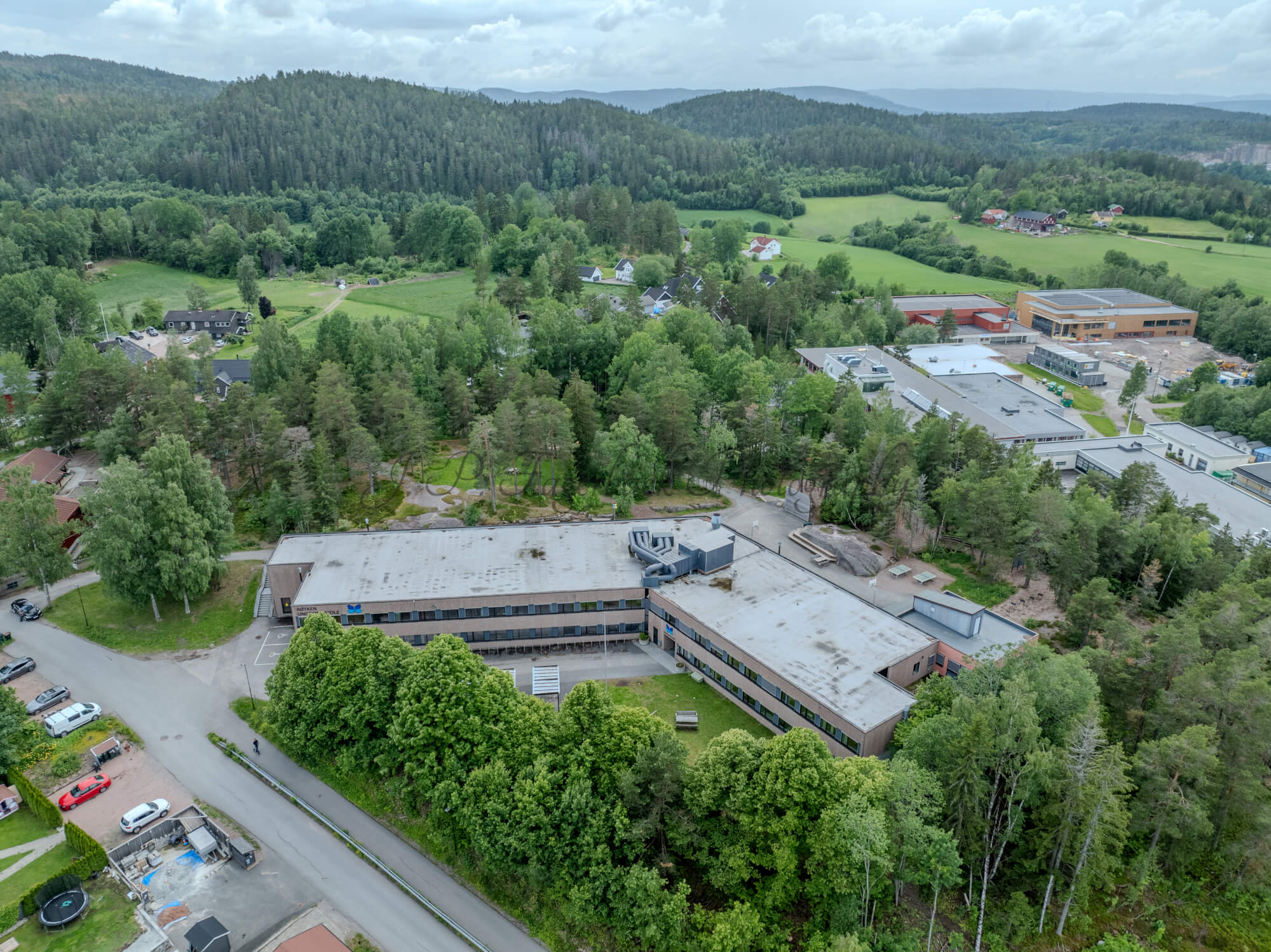 Buildings in a wooded green area under a partially clouded blue sky